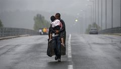 Uprchlík s díttem v deti na hranicích mezi eckem a Makedonií.