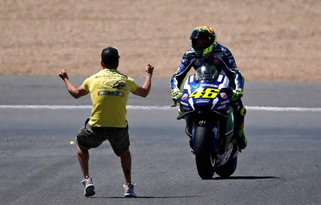 Valentino Rossi a ílený fanouek na trati.