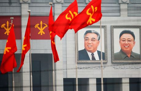 Ikonické portréty Kim Ir-sena a Kim ong-ila vedle znaku Korejské strany práce.
