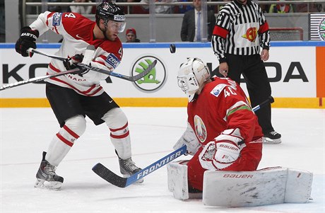 Kanaďan Taylor Hall se snaží překonat běloruského gólmana Dmitriho Milčakova.