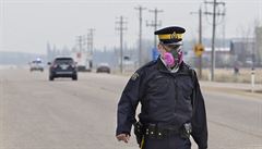 Policista s plynovou maskou organizuje evakuaci.
