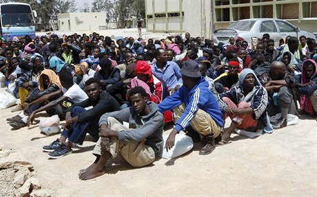 Migranti v Libyi čekají na převoz do imigračního střediska.