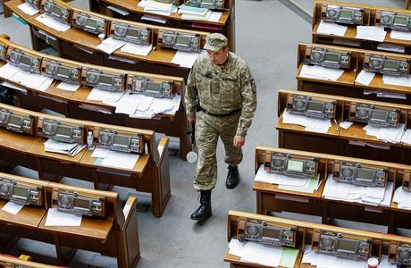 Písluník SBU kontroluje bezpenost v síni kyjevského parlamentu.