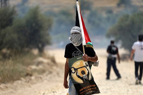 Ilustraní foto. Maskující protestující s palestinskou vlajkou. 