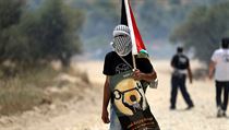 Maskovan protestujc s palestinskou vlajkou bhem stet s izraelskmi...