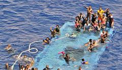 Lidé na potopené lodi u b�ehu Lybie �ekají na pomoc.