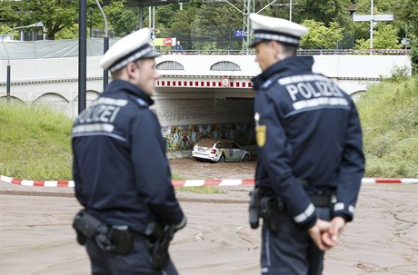 Nmetí policisté v blátem pokryté ulici poblí vlakové stanice ve mst...