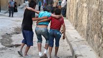 Chlapci pomáhají svému zraněnému kamarádovi po náletem na rebely drženou čtvrť...
