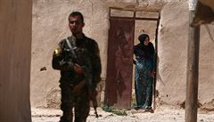 Bojovník Syrských demokratických sil stojí vedle thotné eny ve vesnici na...