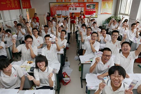 Čínští studenti pózují s pětijüanovou bankovkou v rukách před zkouškami...