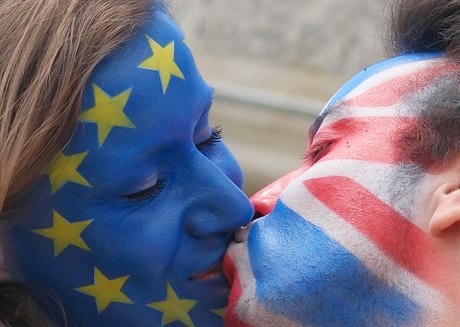 Mladý pár s oblieji pomalovanými vlajkou EU a UK se líbají v Berlín na...
