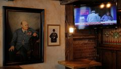 Obraz bývalého premiéra Winstona Churchilla visí vedle televize, na kterém...