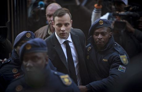 Oscar Pistorius doprovázen policisty do soudní sín v jihoafrické Pretorii.