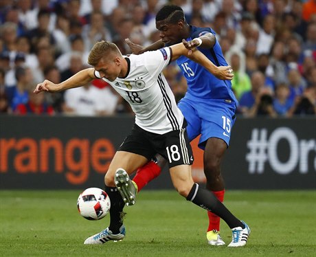 Německý fotbalista Toni Kroos v souboji s Francouzem Paulem Pogbou.