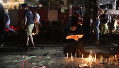 Lidé zapalují svíky na místech bombového útoku v obchodní tvrti Karrada, kde...
