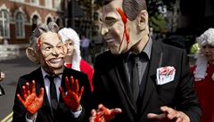 Protestanti pevleeni v maskách bývalého britského premiéra Tonyho Blaira a...