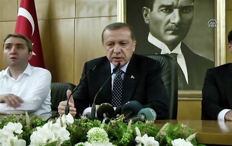 Recep Tayyip Erdogan mluví po pokusu o pevrat. Za ním je obraz Atatürka