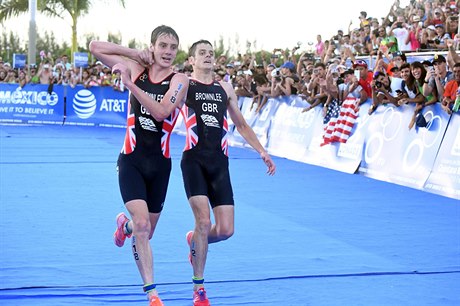 Alistair Brownlee (vlevo) se na zemi objímá s bratrem Jonathanem.