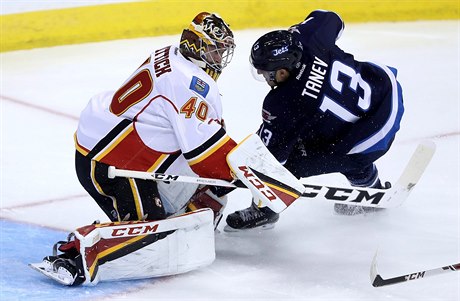 eský branká Calgary David Rittich (40) zastavuje Brandona Taneva (13).