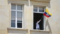 Muž, který vyvěšuje kolumbijskou vlajku jako znak souhlasu s uzavřeným mírem...