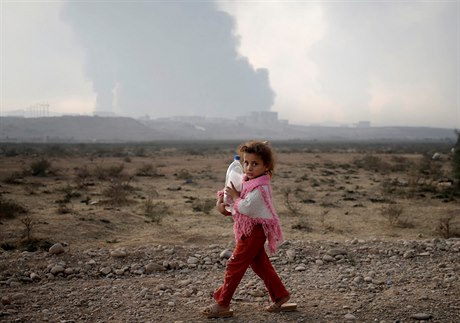 Dívenka drící láhev se prochází v táboe východn od Mosulu.