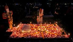 ena zapaluje svíku za své zemelé píbuzné na hbitov v indické Kalkat.