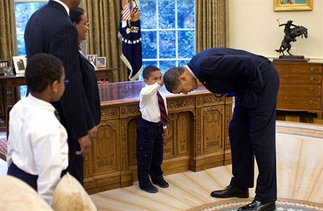 Prezident Obama se skln, aby si syn jednoho z jeho zamstnanc mohl pohladit...