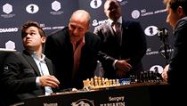 Herec Woody Harrelson pózuje se šachisty Carlsenem a Karjakinem.