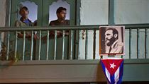 Dvojice obyvatel Havany vyhl z okna jejich bytu. Pod nimi je fotografie...