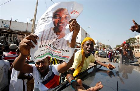 Podporovatel Adama Barrowa drc jeho volebn plakt