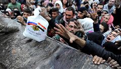 Syřané uprchlí z Aleppa se natahují po ruském balíčku s jídlem.