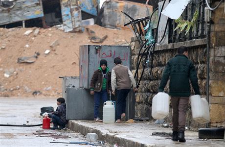 Civilisté ve východním Aleppu si nabírají vodu z kontejner.