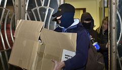 Policisté vycházejí z budovy v praské ulici Na Pertýn, kde byli 14. prosince...