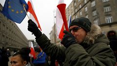 Lidé v ulicích Varavy s vlajkami Polska a EU.