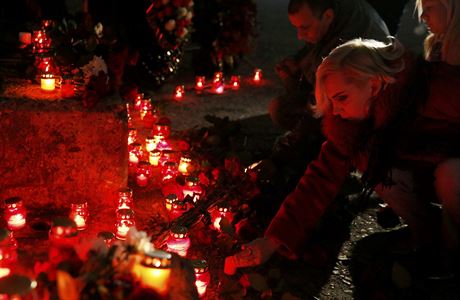 Lidé zapalují svíky za obti zíceného ruského letadla.