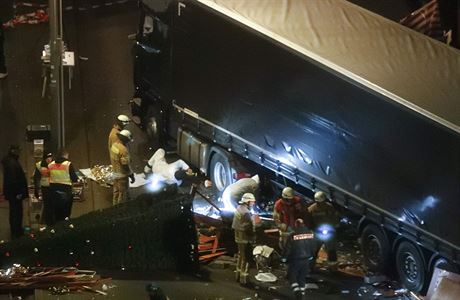 Záchranái a policisté pracují poblí kamionu, který zabil nejmén 12 lidí.