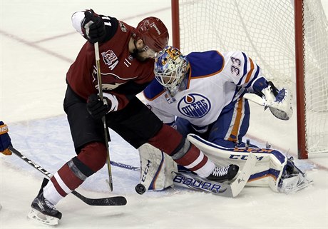 Martin Hanzal z Arizony operuje ped brankáem Edmontonu Camem Talbotem.