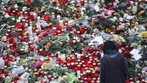 Spousta květin a svíček je položena v blízkosti vánočního trhu v Berlíně...
