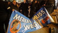 Lidé drí plakát Merkelová musí jít.