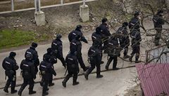 Ruská policie hlídá okolí místa, kde záchranné sloky sbírají trosky.