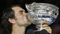 Roger Federer líbá trofej pro vítěze Australian Open.