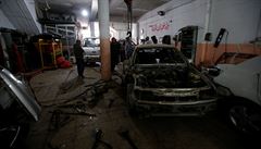 Dlníci na pedmstí Mosulu opravují zniená auta.