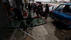 Dlníci opravují elní sklo auta na pedmstí Mosulu.