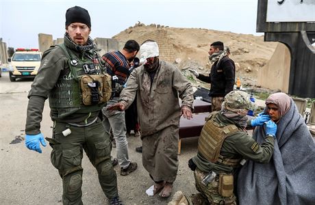 Vojáci pomáhají tce zranným civilistm.