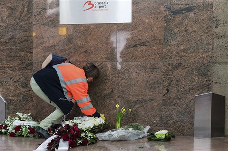 Zamstnankyn bruselského letit pokládá kvtinu  na místo, kde si lidé...