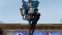 Policista sundav demonstranty z lampy bhem protest v Rusku.