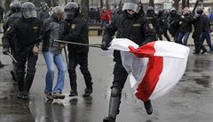 A Belarus policeman runs with an opposition flag as other detain a protester...