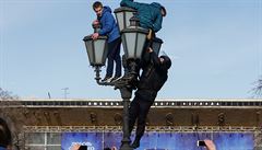 Policista sundavá demonstranty z lampy bhem protest v Rusku.