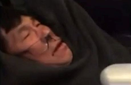 Snímek zachycuje jak Davida Dao ochranka násilím vytahuje z letadla. V koutku...