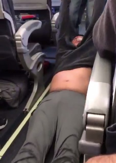 Snímek zachycuje jak Davida Dao ochranka násilím vytahuje z letadla.